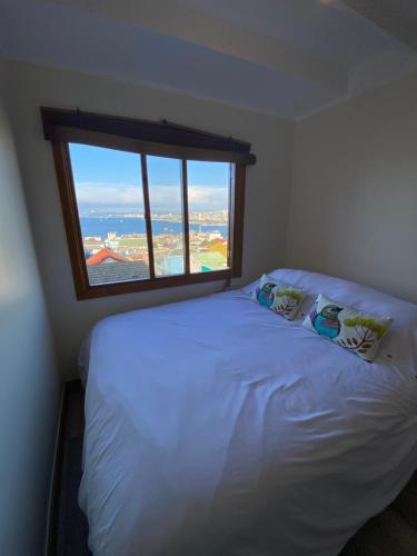 瓦尔帕莱索Oasis en Cerro Alegre的卧室配有白色的床和大窗户