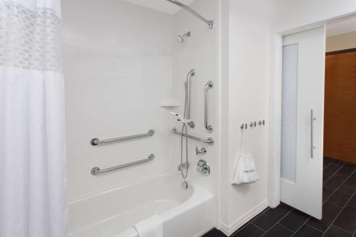穆恩斯特曼斯特汉普顿酒店及套房的白色的浴室设有浴缸和淋浴。