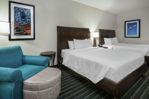 圣安东尼奥圣安东尼奥/瑞姆帕斯得里弗希尔顿花园酒店的酒店客房,配有两张床和椅子