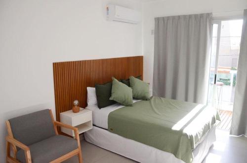 拉普拉塔Casa14的卧室配有床、椅子和窗户。