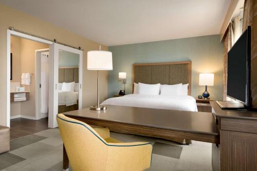门罗梦露汉普顿套房旅馆的酒店客房配有一张床、一张书桌