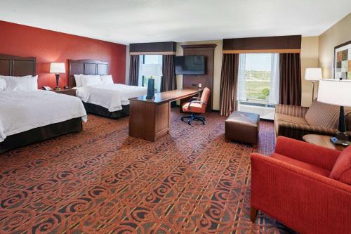 富兰克林密尔沃基/富兰克林汉普顿酒店的酒店客房带两张床、一张书桌和一张沙发