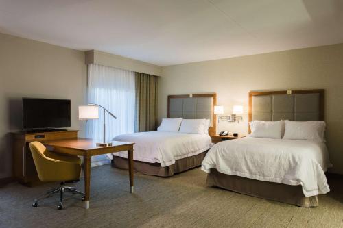 诺克斯维尔田纳西诺克斯维尔佩普米尔路汉普顿酒店的酒店客房设有两张床、一张桌子和一台电视。