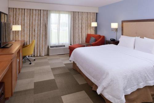 Lonoke希尔顿洛诺克汉普顿套房酒店的酒店客房设有一张大床和一台电视。