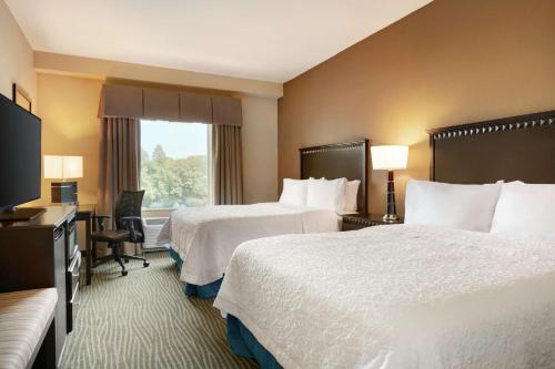帕克斯堡汉普顿帕克市中心酒店（Hampton Inn and Suites Parkersburg Downtown）的酒店客房设有两张床和电视。