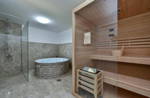特美好Ruralna kuća za odmor RAJSKI MIR的带浴缸和玻璃淋浴间的浴室。