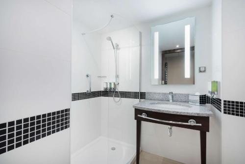 克拉科夫克拉科夫希尔顿汉普顿酒店的一间带水槽、淋浴和镜子的浴室
