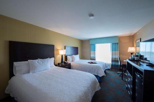 萨斯卡通南萨斯卡通汉普顿酒店的酒店客房设有两张床和窗户。