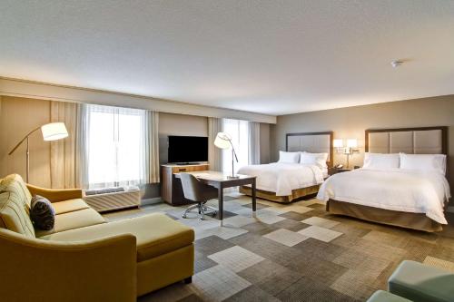 萨斯卡通希尔顿萨斯卡通机场汉普顿套房酒店的酒店客房,设有两张床和一张沙发