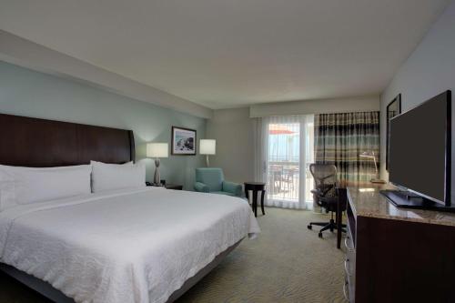 代托纳海滩代托纳海滩海滨希尔顿花园酒店的配有一张床和一台平面电视的酒店客房
