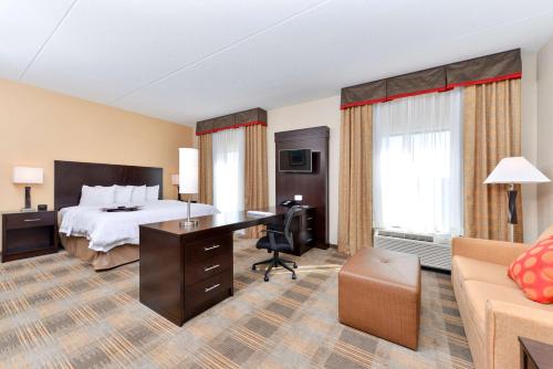 Coal Center加州大学 - 匹兹堡汉普顿酒店及套房的配有一张床和一张书桌的酒店客房