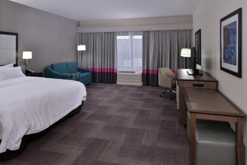 莱温芙丝莱文沃思汉普顿酒店的酒店客房,配有一张床、一张桌子和椅子