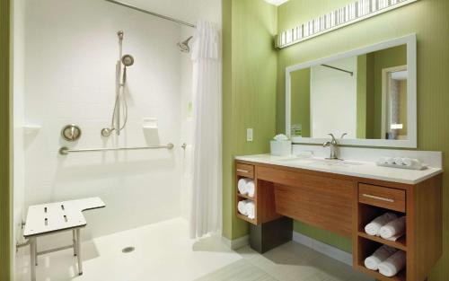 布卢明顿布卢明顿明尼阿波利斯希尔顿欣庭套房酒店的浴室配有盥洗盆和带镜子的淋浴