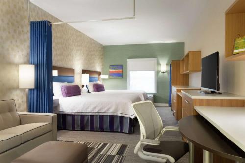米尔顿安大略省米尔顿希尔顿欣庭套房酒店的配有一张床和一张书桌的酒店客房