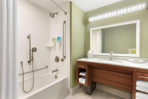 米尔顿安大略省米尔顿希尔顿欣庭套房酒店的一间带水槽、浴缸和镜子的浴室