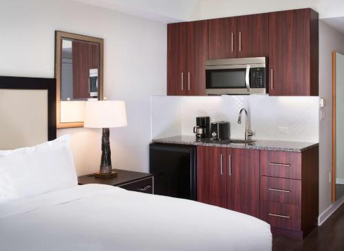 奥兰多Hilton Grand Vacations Club Las Palmeras Orlando的酒店客房带一张床和一台微波炉