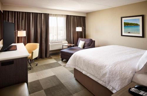 Point Edward萨尼亚/爱德华点汉普顿酒店的酒店的客房 - 带一张床、椅子和窗户