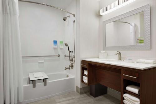 西门罗Home2 Suites by Hilton West Monroe的带浴缸、水槽和镜子的浴室