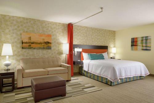 亚历山德里亚亚历山德里亚希尔顿欣庭套房酒店的大型酒店客房,配有床和沙发