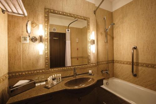 锡吉什瓦拉锡吉什瓦拉卡瓦勒希尔顿逸林酒店的一间带水槽、浴缸和镜子的浴室