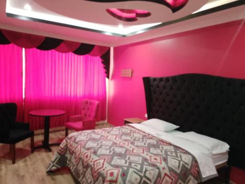 基多Hostal Boston 2的粉红色的卧室,配有一张床和粉红色的墙壁