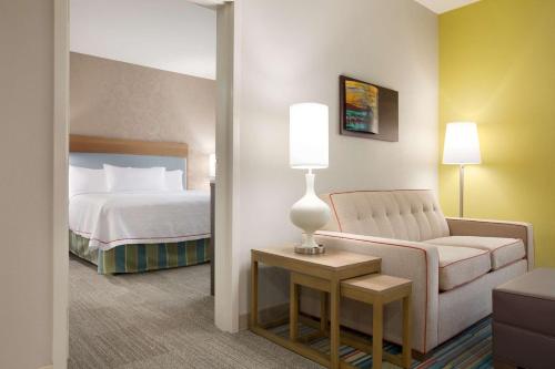 兀兰兀兰希尔顿欣庭套房酒店的酒店客房配有床、沙发和椅子
