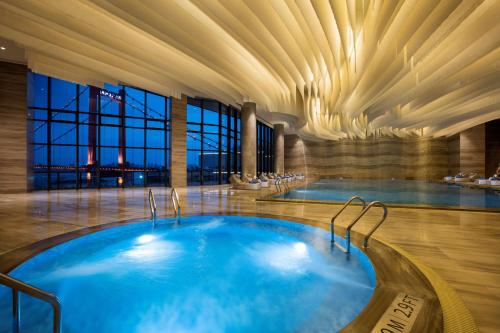 武汉武汉世茂希尔顿酒店 - 长江江景的一座带天花板的酒店游泳池