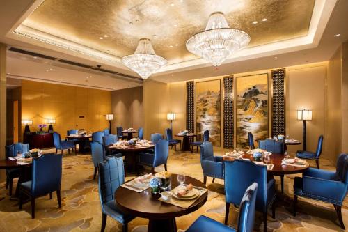 武汉武汉世茂希尔顿酒店 - 长江江景的用餐室配有桌椅和吊灯。