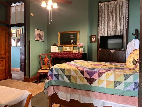 印第安纳波利斯Mansion on The Mile B&B的一间卧室配有一张床和一台平面电视