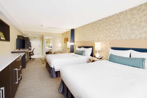 绍姆堡绍姆堡芝加哥希尔顿欣庭套房酒店的酒店客房配有两张床和一张书桌