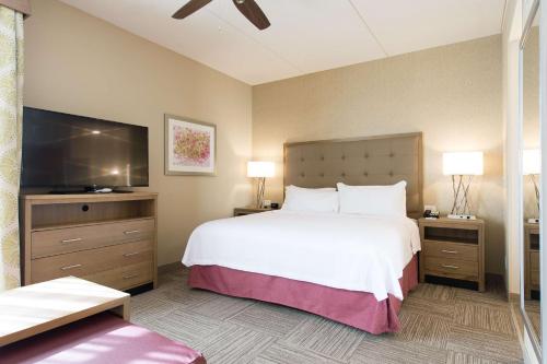 康科德Homewood Suites by Hilton Concord的一间卧室配有一张大床和一台平面电视