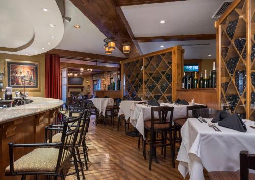 帕克城傲途格精选酒店帕克城的一间设有白色桌椅的餐厅和一间酒吧