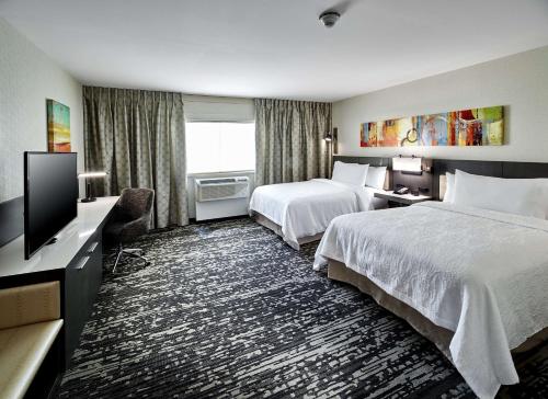 Roslyn罗斯林希尔顿花园酒店的酒店客房设有两张床和一台平面电视。