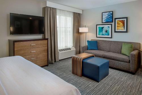 马里兰高地圣路易斯韦斯特波特希尔顿惠庭套房酒店的一间配备有沙发及电视的酒店客房