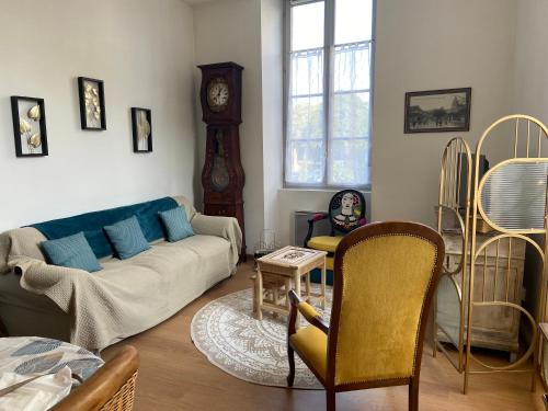 多勒Chez Faustin et Félicie Appartement 2 chambres Place Grevy的带沙发和祖父钟的客厅