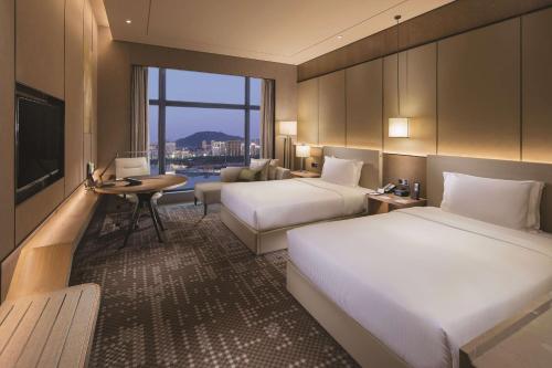 厦门厦门海沧正元希尔顿逸林酒店的酒店客房设有两张床和电视。