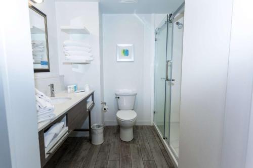 北锡拉丘兹雪城华美达酒店的一间带卫生间和玻璃淋浴间的浴室