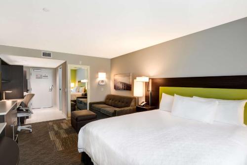 阿苏萨阿苏萨希尔顿惠庭酒店的酒店客房设有一张大床和一间客厅。