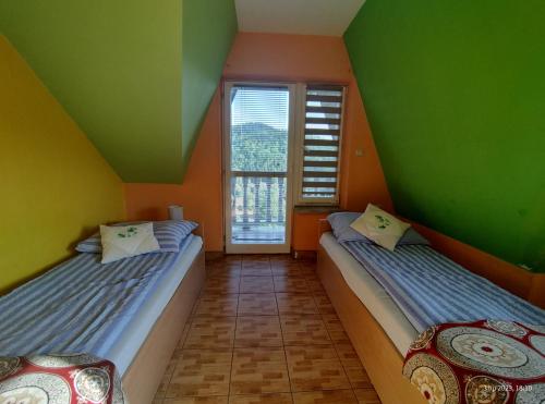 FalsztynTanie Noclegi Krysia Falsztyn的绿橙色墙壁的客房内的两张床