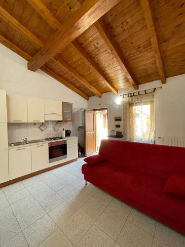 维杰瓦诺Appartamento tranquillo a due passi dal centro的客厅设有红色沙发,位于厨房内