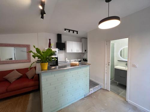 埃梅Le Patio d’Eymet的一间厨房和一间带红色沙发的客厅