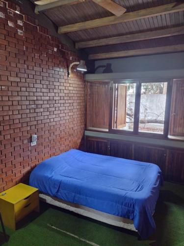 门多萨OlasHostel的一间设有蓝色床的砖墙卧室