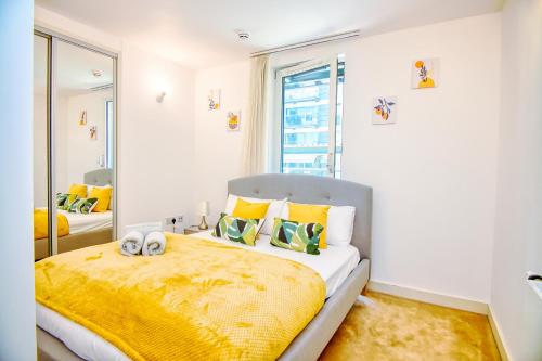 海斯Your gateway to London & Heathrow, Stylish flat near station的一间卧室配有一张带黄色毯子的大床