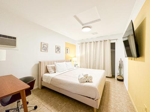 伯班克Charming 1 BR Poolside Retreat - Lou2-Bur的一间卧室配有一张床、一张书桌和一台电视