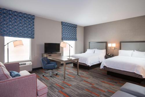 威斯康星戴尔Hampton Inn and Suites at Wisconsin Dells Lake Delton的酒店客房配有两张床和一张书桌
