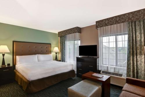 奥罗拉诺福拉诺珀维尔希尔顿惠庭套房酒店的配有一张床和一台平面电视的酒店客房