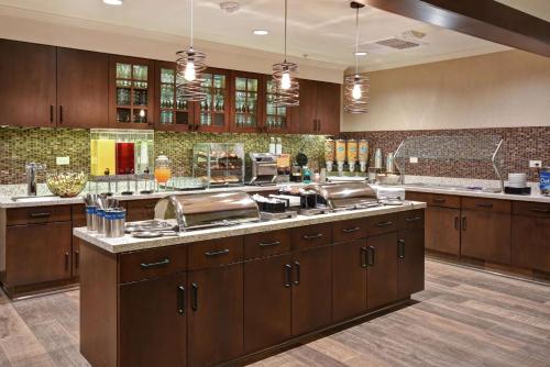 普莱森特希尔Homewood Suites by Hilton Pleasant Hill Concord的一个带木制橱柜和不锈钢用具的大厨房