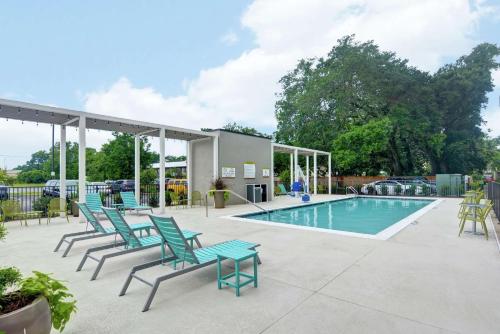 彭萨科拉Home2 Suites Pensacola I-10 At North Davis Hwy的一个带椅子的庭院和一个游泳池