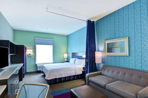 彭萨科拉Home2 Suites Pensacola I-10 At North Davis Hwy的酒店客房,配有床和沙发