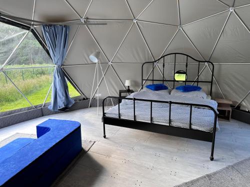 ŚciegnyGlamping Stodoła Dome的帐篷内一间卧室,配有一张床